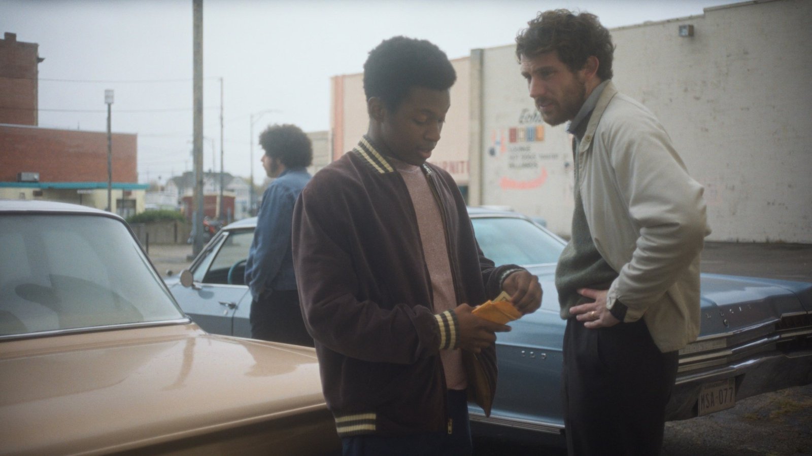 images-3-fill_-size_2000x1125-v1758901851 A group of men stand beside two cards in "The Mastermind."