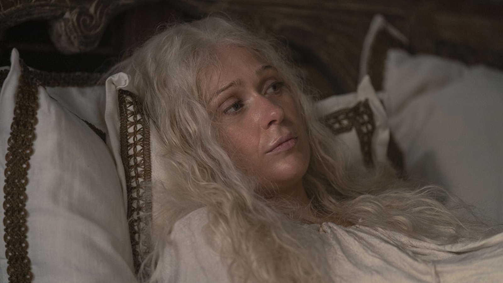 images-3-fill_-size_2000x1126-v1715869796 A woman lies on a bed, looking unwell.